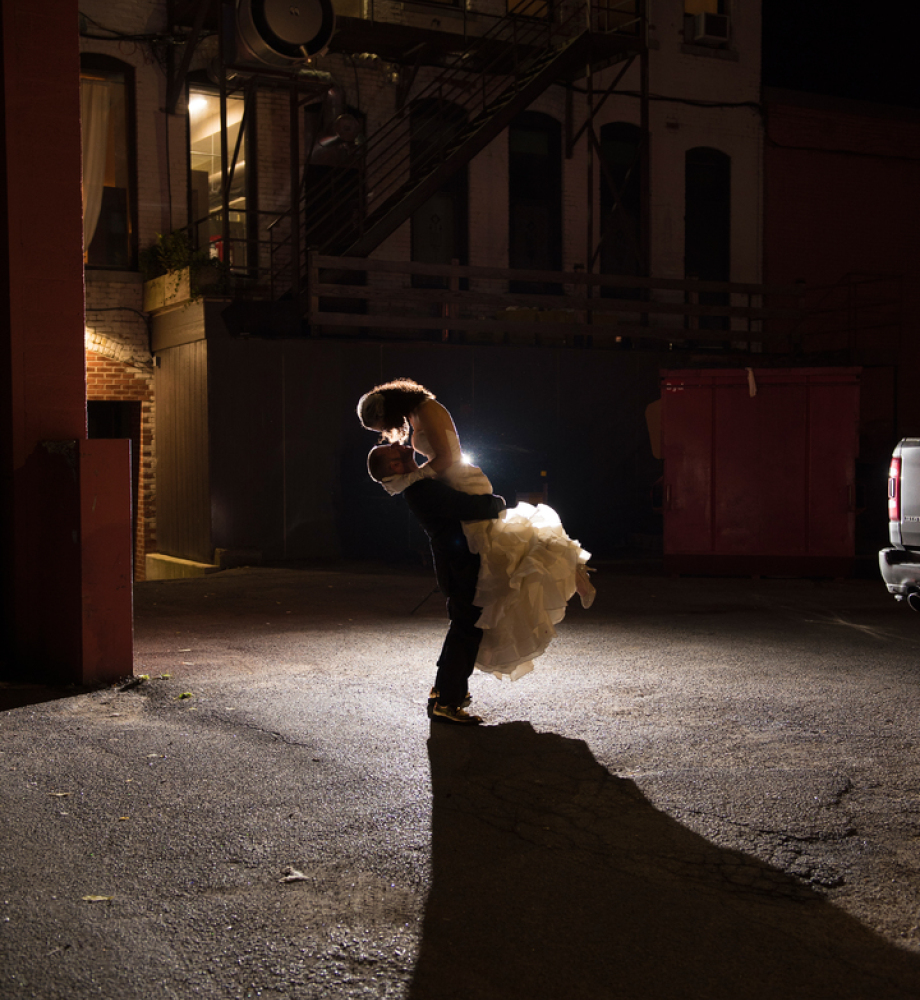 bride and groom in alleyway backlit.